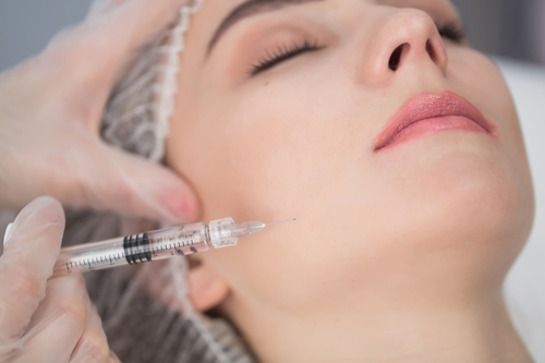 Cosmetic injection of botox, close-up. Woman gets injection in her face.